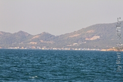 Koh Larn im Dunst mit Ortschaft am Strand
